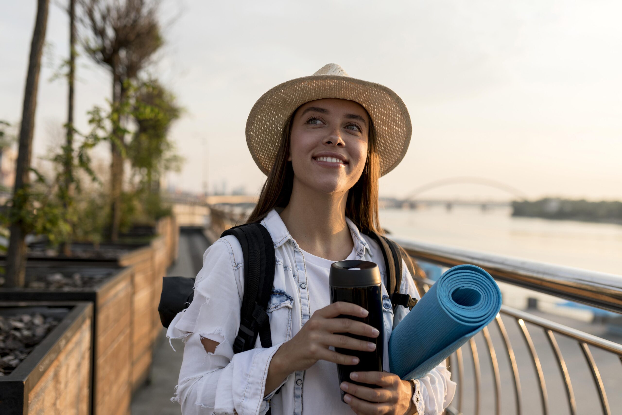 vista-frontal-de-la-mujer-con-mochila-y-sombrero-sosteniendo-termo-mientras-viaja